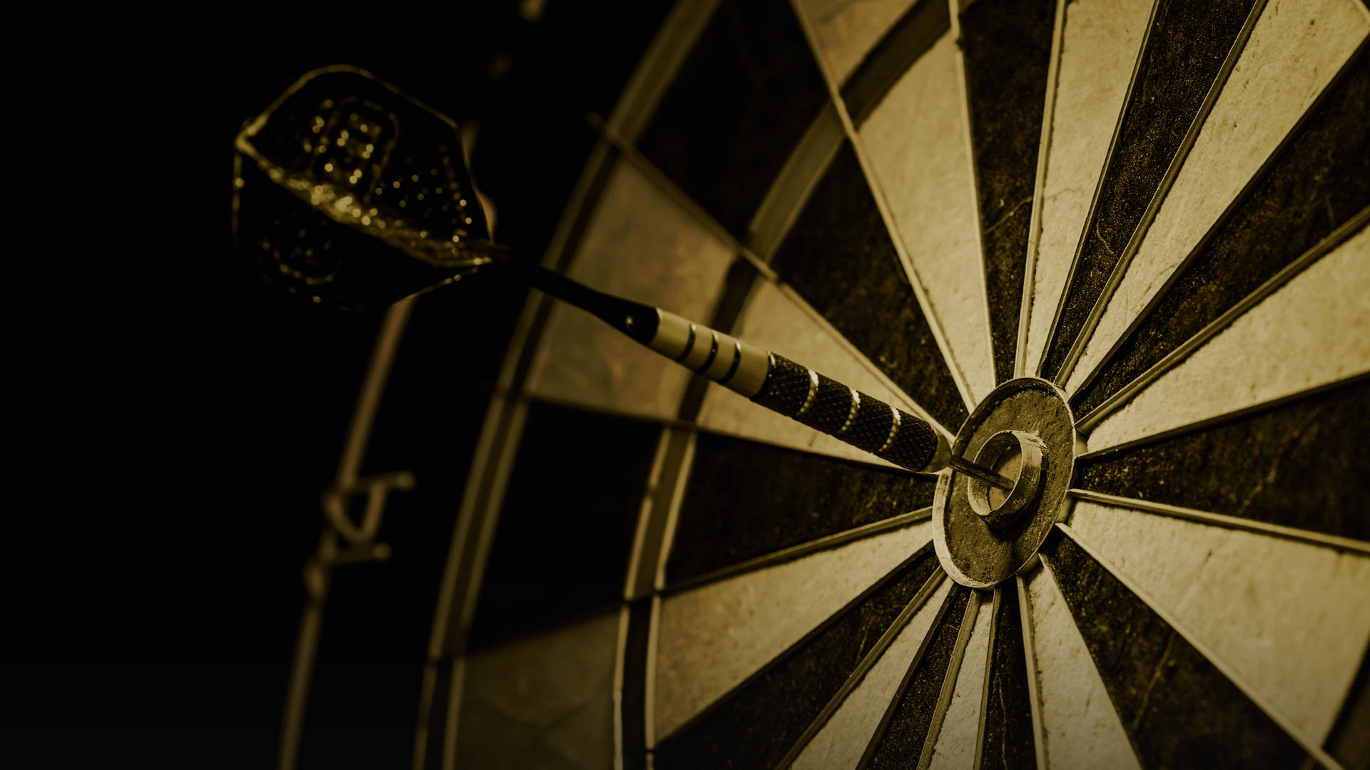 A hand holding three darts, poised to throw at a dartboard with the BetMGM logo.